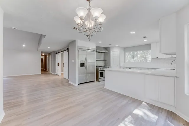 a view of a kitchen with refrigerator and a sink