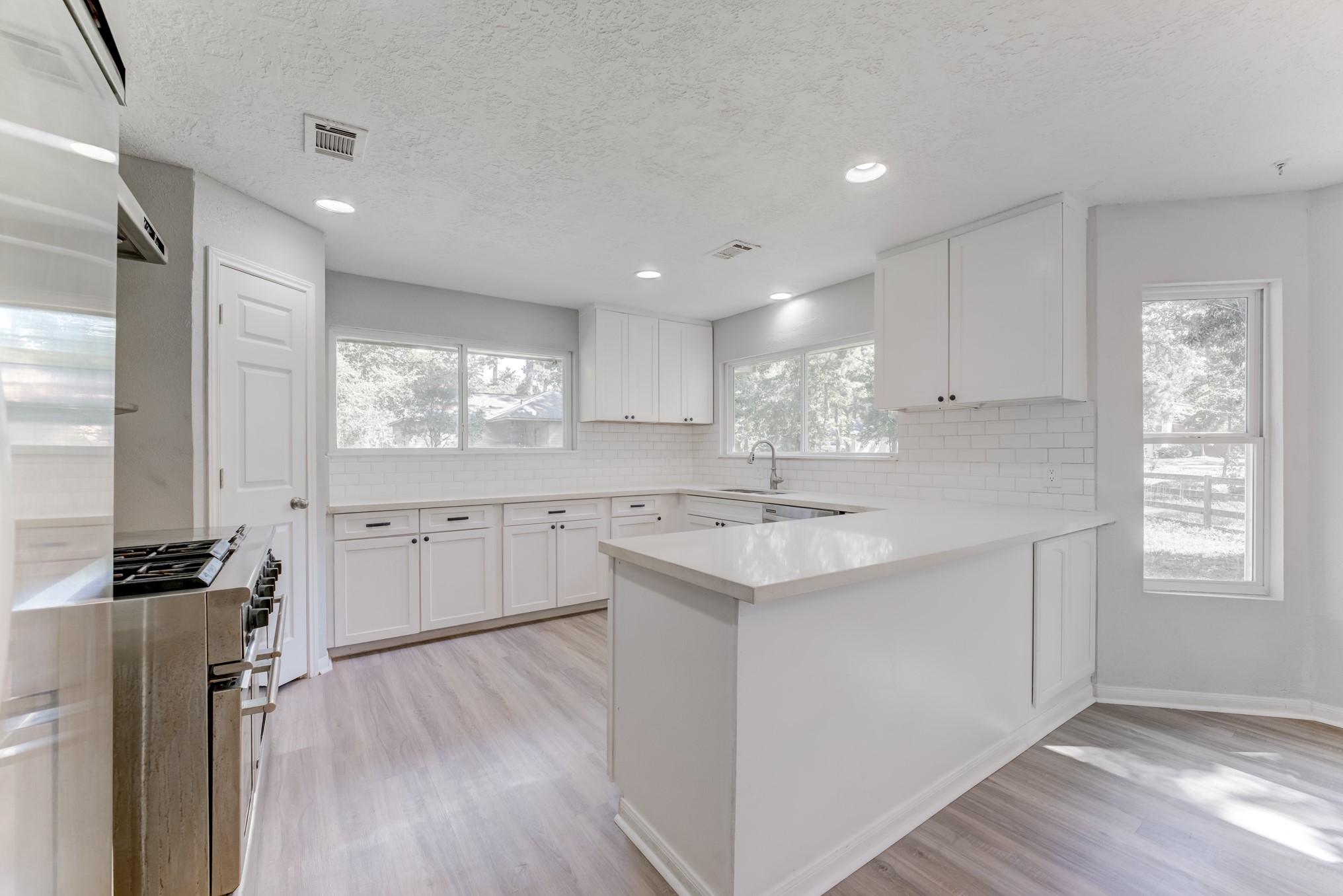 81 Oak Grove Lane Conroe, TX 77304 - Photo 5 of 50 a kitchen with a sink wooden floor and white cabinets