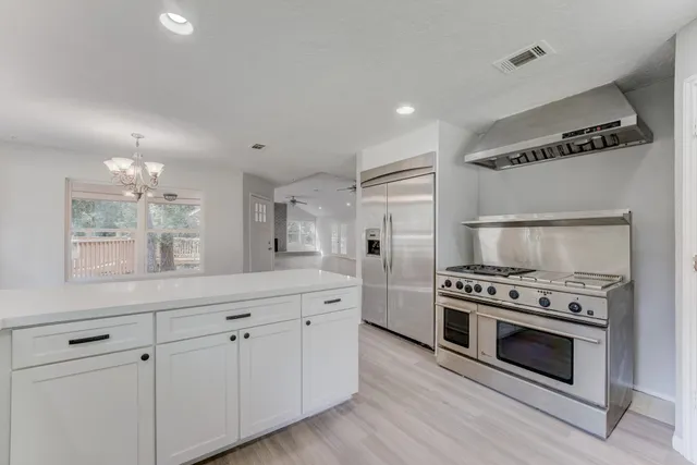a kitchen with white cabinets and stainless steel appliances
