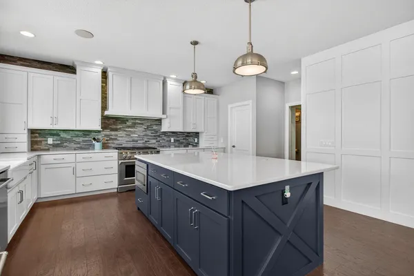 a kitchen with stainless steel appliances a sink dishwasher stove refrigerator and cabinets