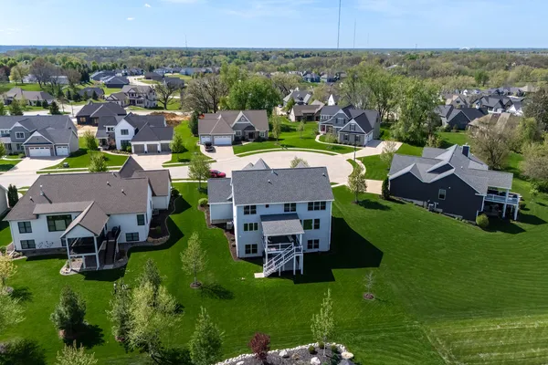 an aerial view of a house with a garden and lake view