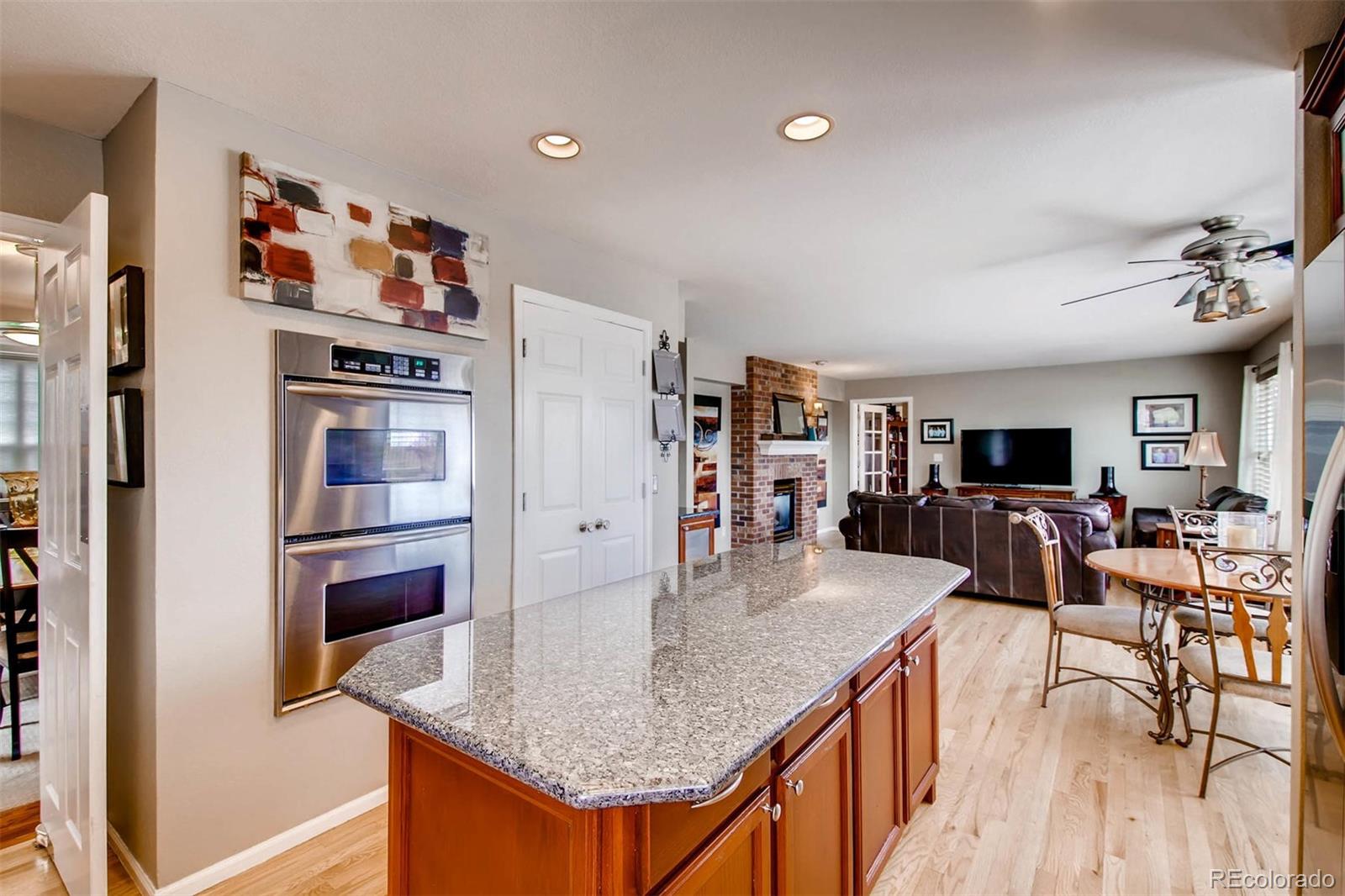 1665 Spring Water Lane Highlands Ranch, CO 80129 - Photo 13 of 34 a kitchen with stainless steel appliances granite countertop a refrigerator a stove and a sink with wooden floor