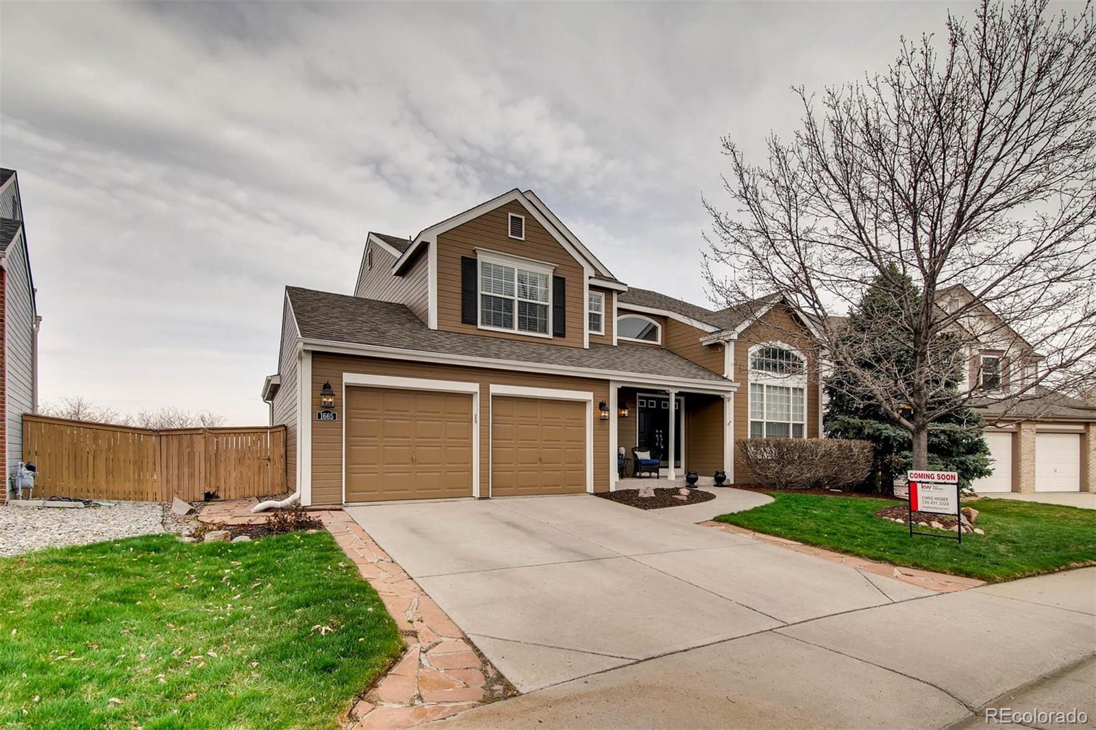 1665 Spring Water Lane Highlands Ranch, CO 80129 - Photo 3 of 34 a front view of a house with a yard and garage