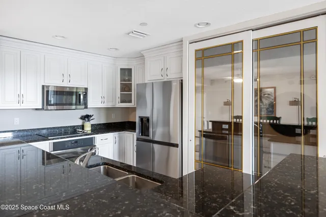 a kitchen with stainless steel appliances kitchen island granite countertop a refrigerator and a stove