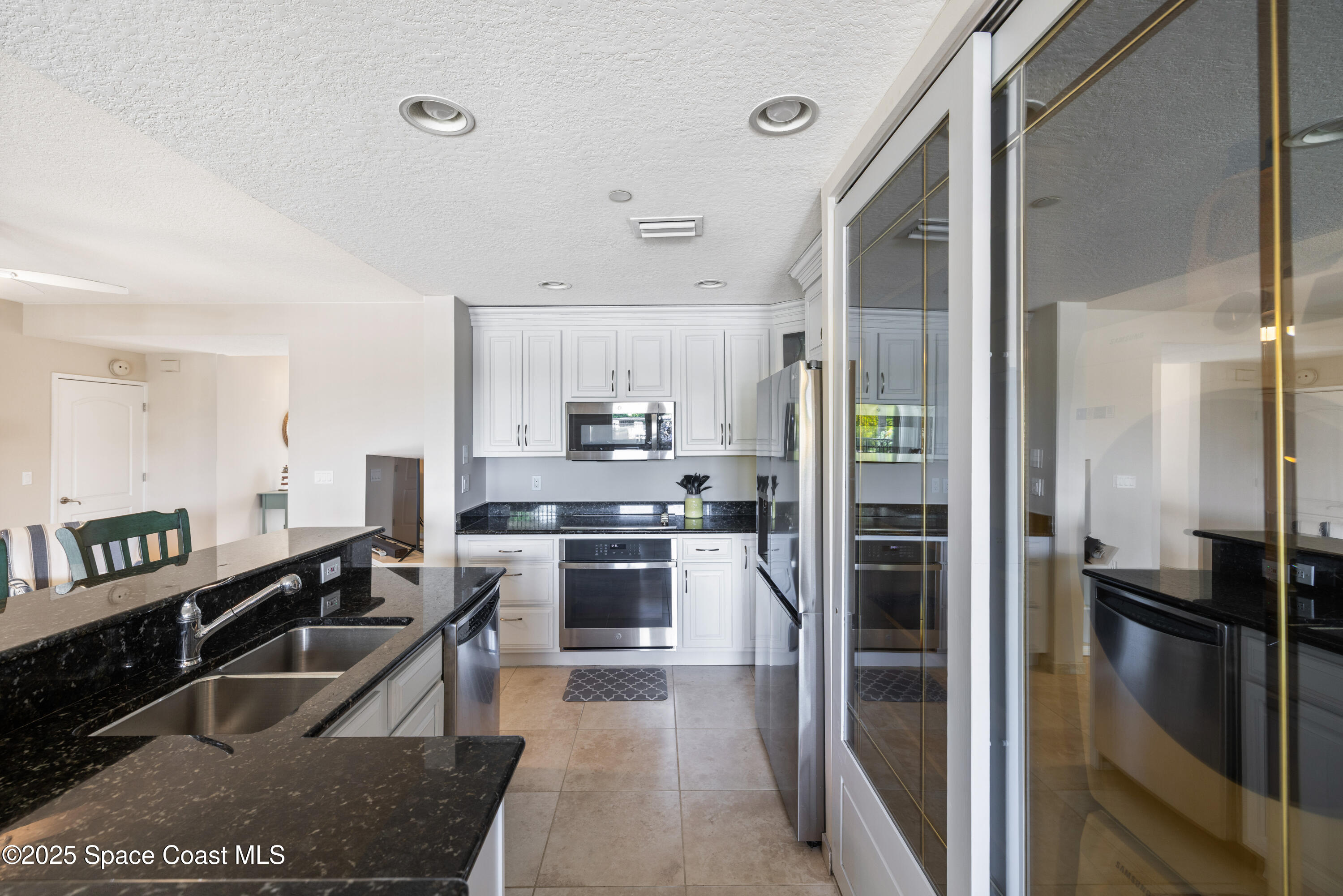 1623 Indian River Drive, Unit 103 Sebastian, FL 32958 - Photo 20 of 36 a kitchen with stainless steel appliances kitchen island granite countertop a refrigerator and a stove