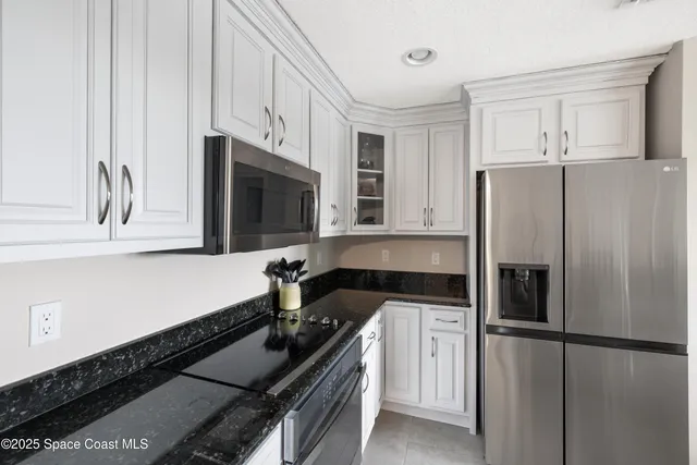 a bedroom with a large bed and a flat tv screen on dresser