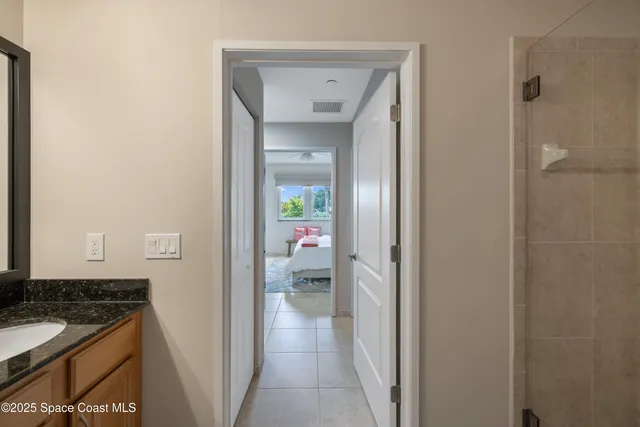 a bathroom with a granite countertop sink and a mirror with toilet