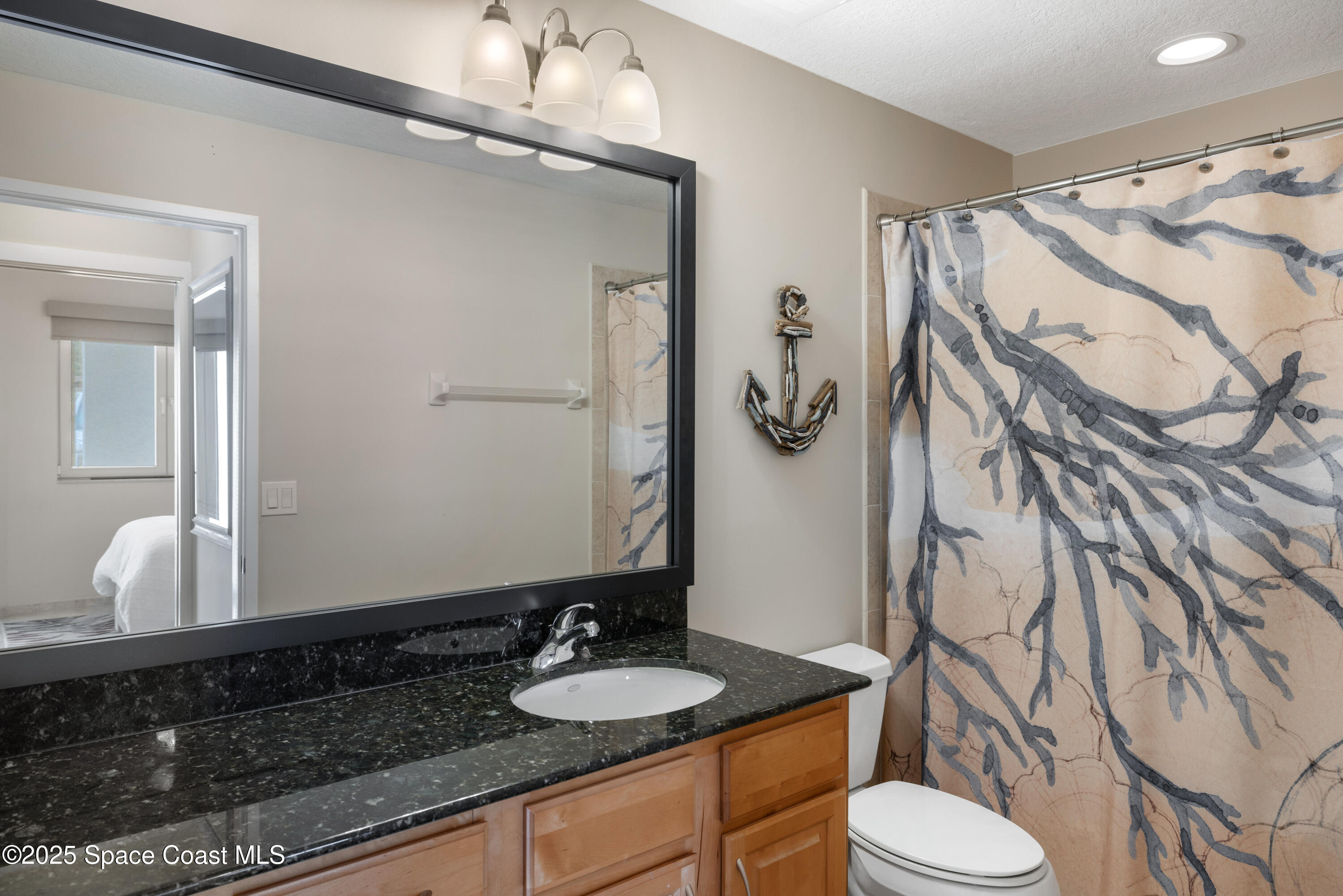 1623 Indian River Drive, Unit 103 Sebastian, FL 32958 - Photo 35 of 36 a bathroom with a granite countertop sink and a mirror with toilet