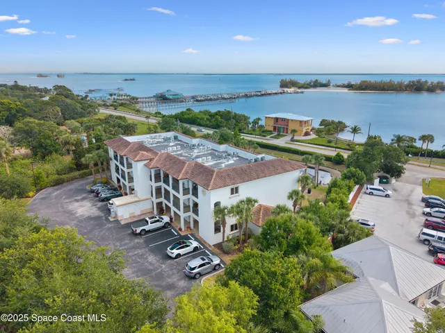 an aerial view of a house with a garden and lake view