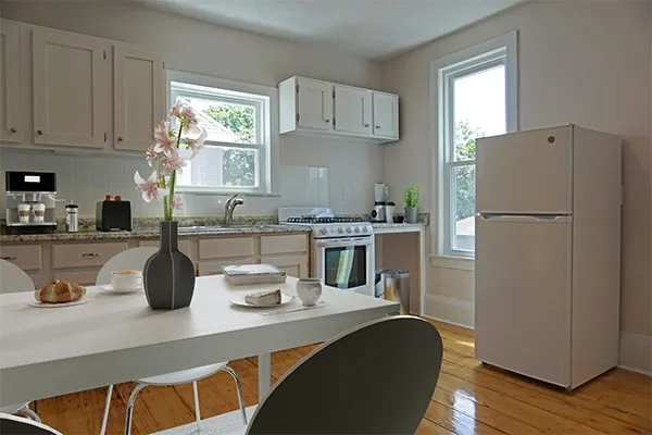 a kitchen with a refrigerator and white cabinets