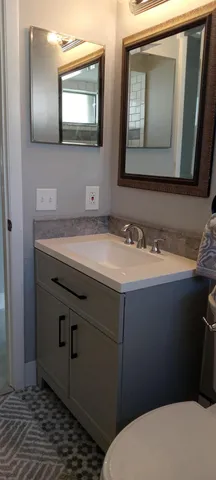 a bathroom with a toilet sink and mirror