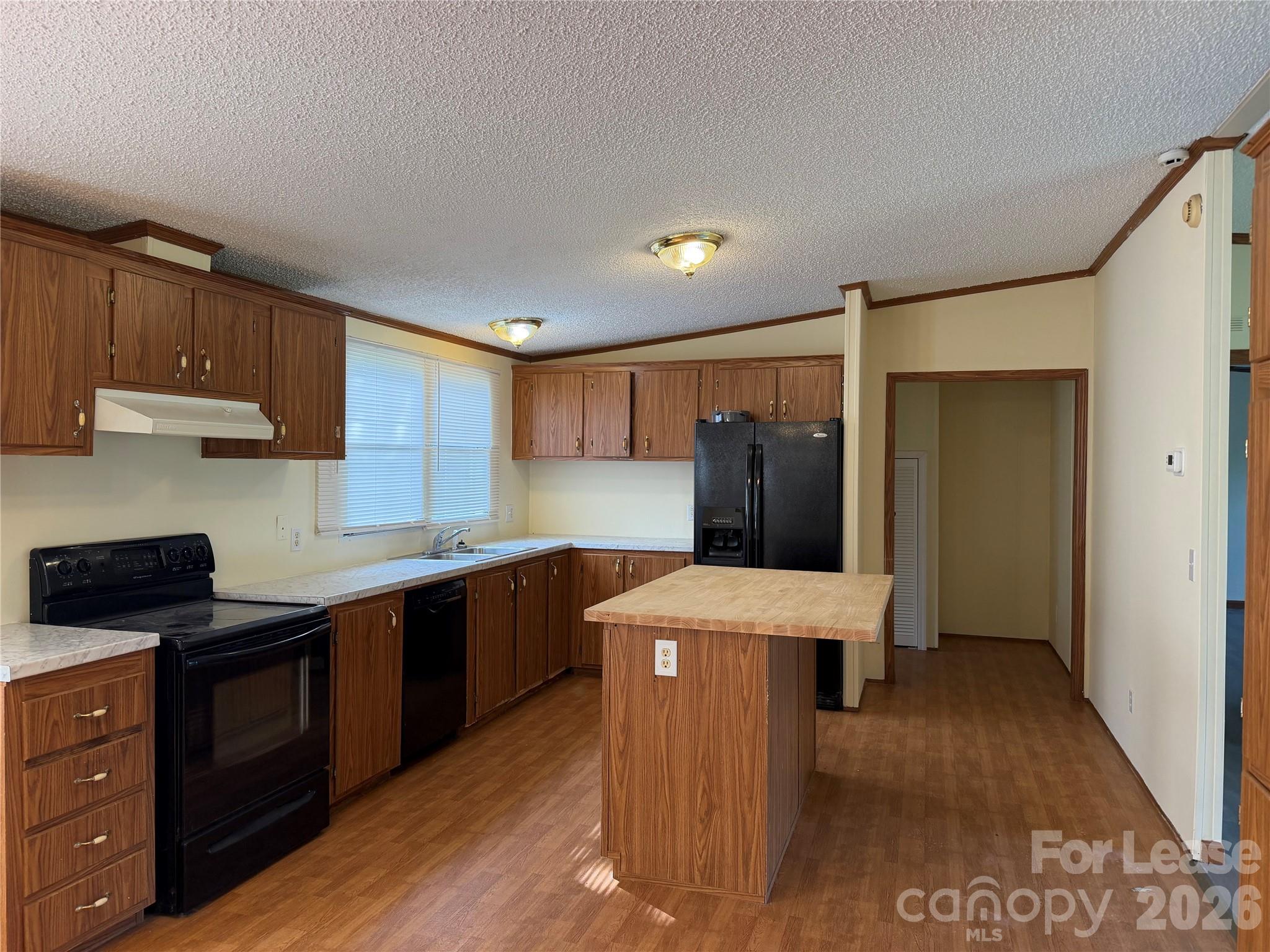 7141 Lingerfelt Road Vale, NC 28168 - Photo 10 of 25 a kitchen with stainless steel appliances kitchen island granite countertop a refrigerator a sink and wooden cabinets
