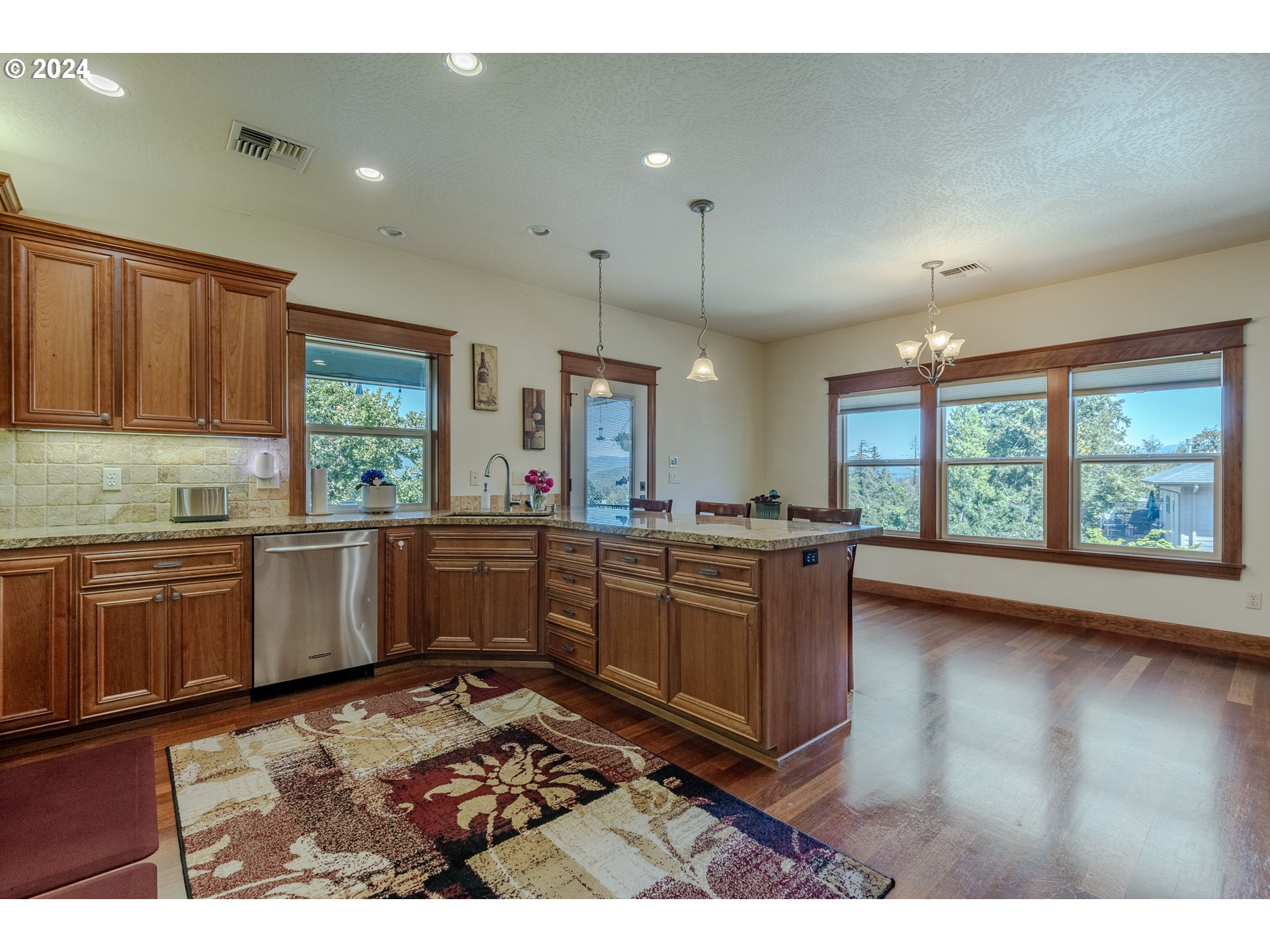 6188 Fernhill Loop Springfield, OR 97478 - Photo 15 of 40 a kitchen with stainless steel appliances kitchen island granite countertop a stove a sink and a microwave