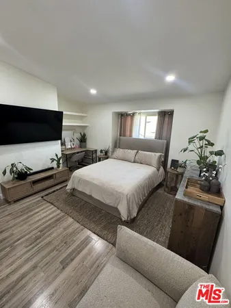 a bedroom with bed and a flat screen tv