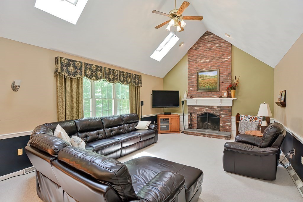 2 Harrison Place Franklin, MA 02038 - Photo 13 of 34 a living room with furniture a fireplace and a flat screen tv