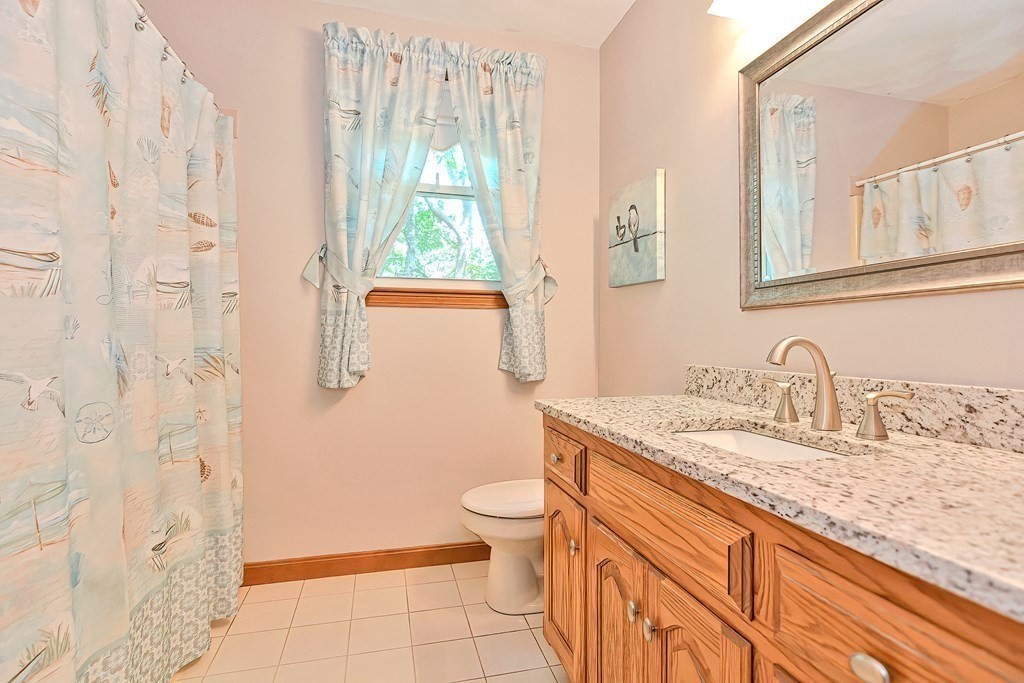 2 Harrison Place Franklin, MA 02038 - Photo 26 of 34 a bathroom with a granite countertop sink a toilet a mirror and shower curtain