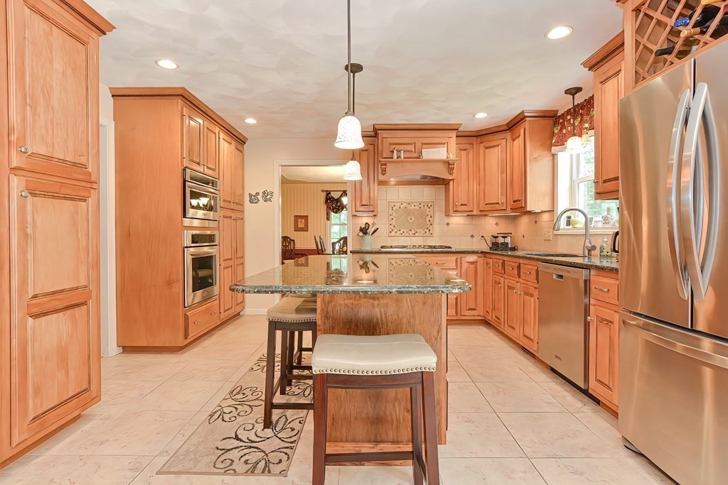2 Harrison Place Franklin, MA 02038 - Photo 10 of 34 a kitchen with stainless steel appliances kitchen island granite countertop a refrigerator and a stove top oven
