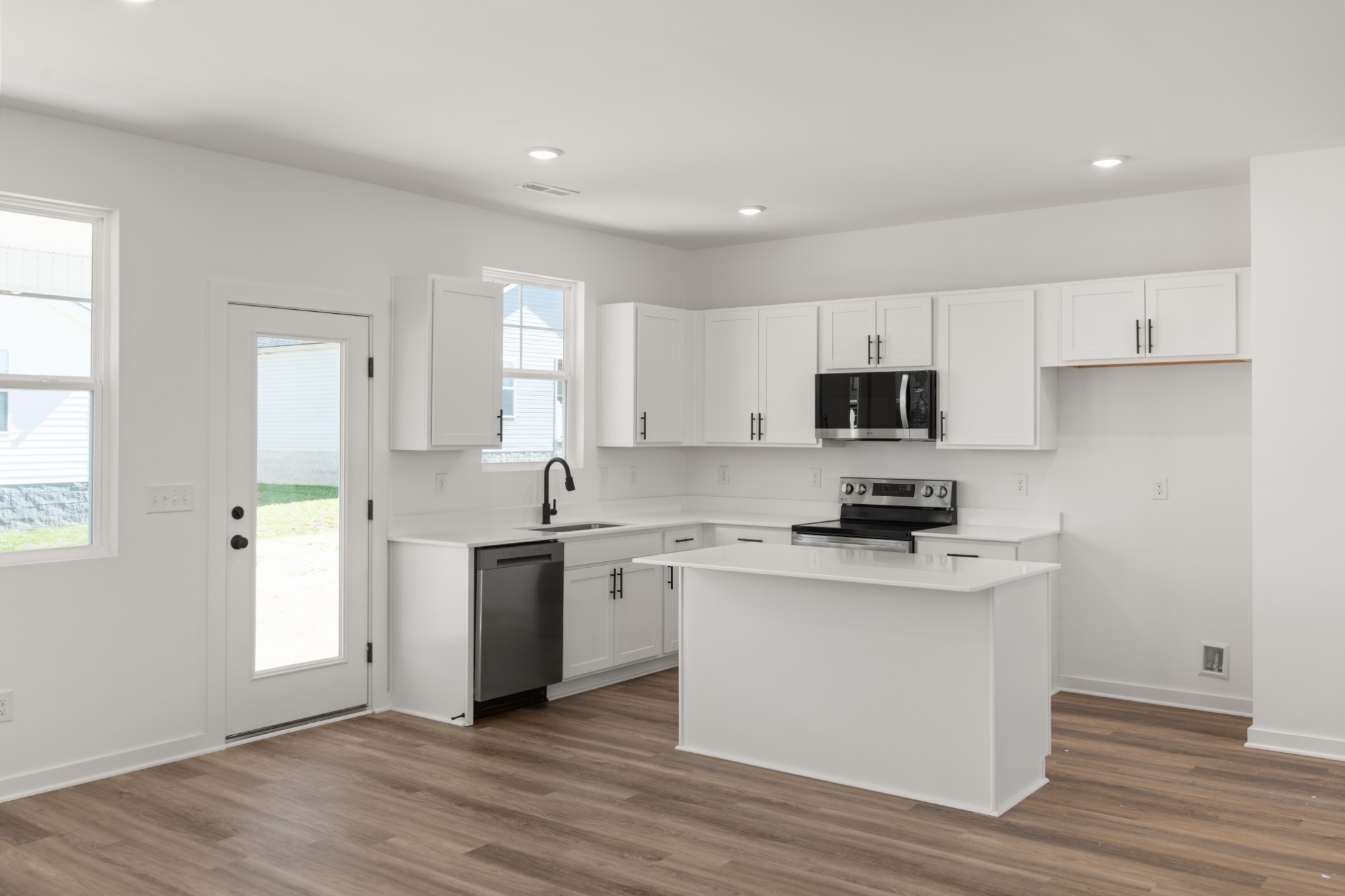 219 Reece Road Baxter, TN 38544 - Photo 5 of 10 a kitchen with stainless steel appliances granite countertop a stove top oven a sink a refrigerator white cabinets and wooden floor