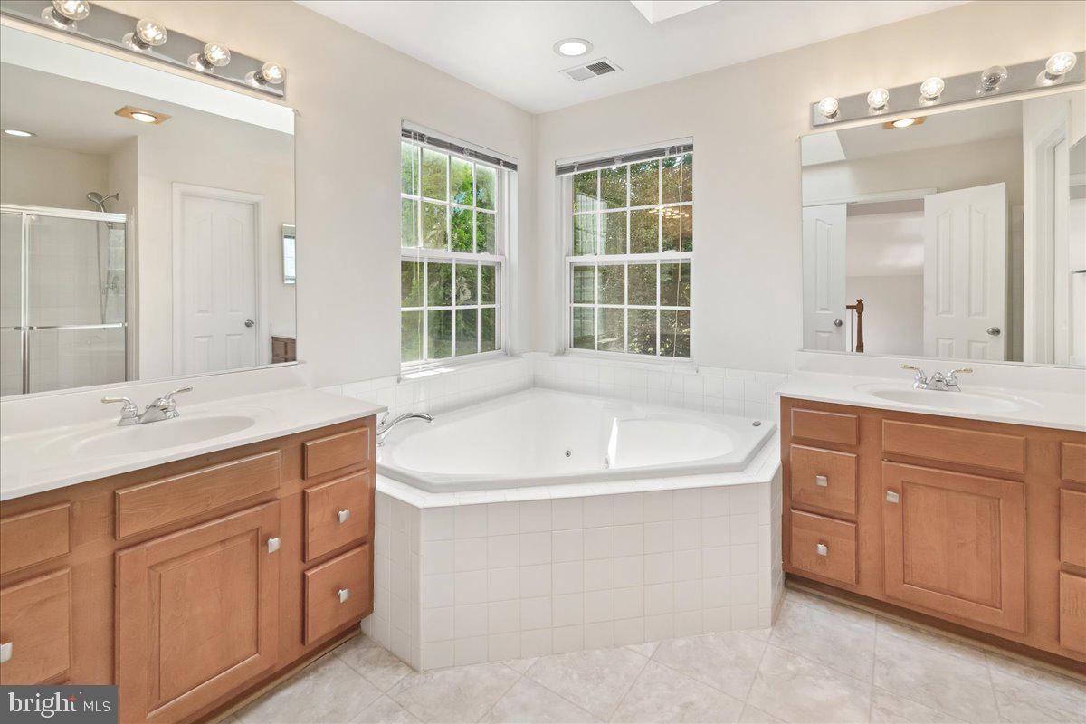 1712 Wheyfield Drive Frederick, MD 21701 - Photo 32 of 64 a bathroom with a granite countertop double vanity sink a mirror and a bathtub