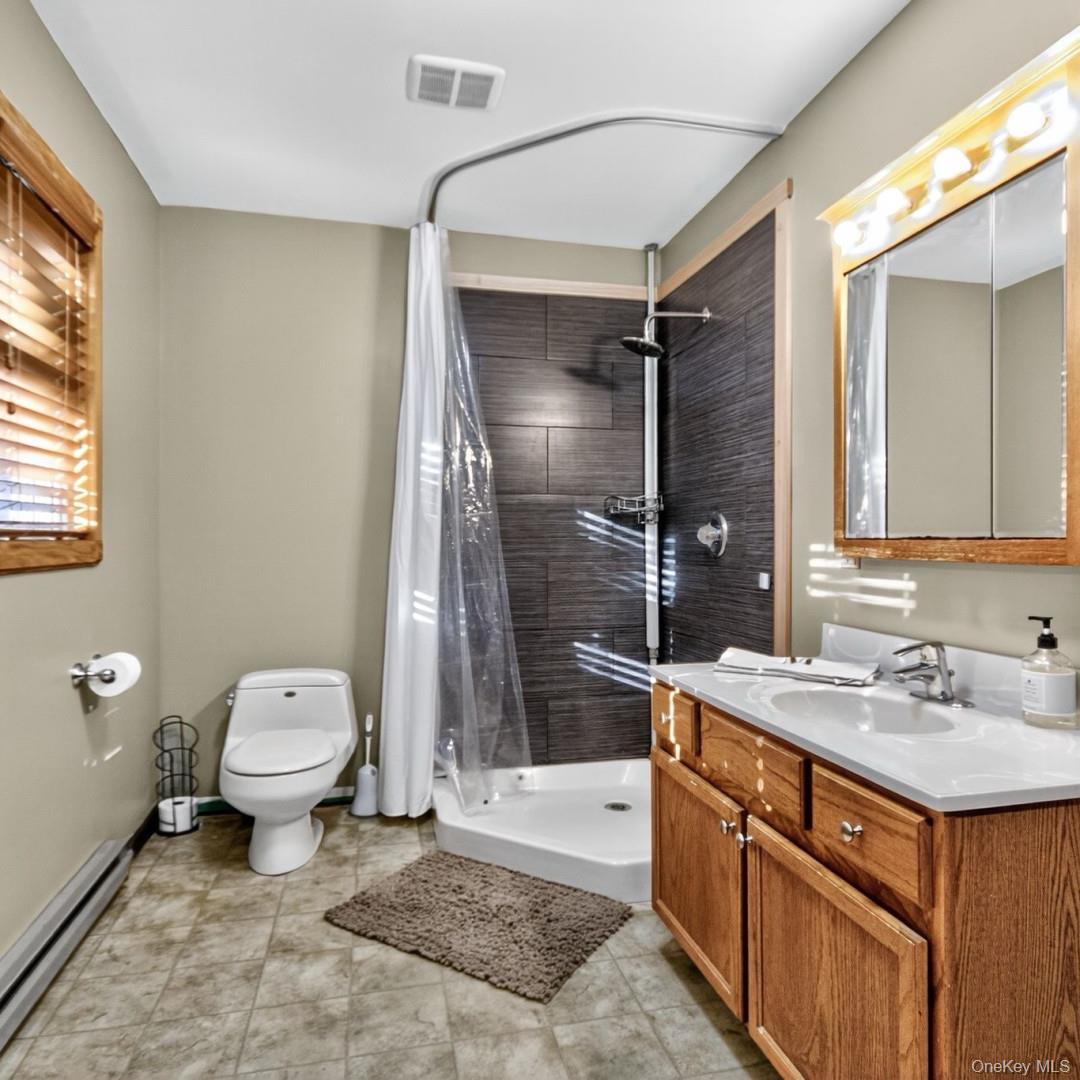 69 Crabby Road Loch Sheldrake, NY 12759 - Photo 18 of 20 a bathroom with a sink toilet and shower