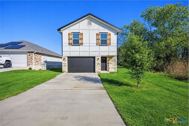 a front view of a house with a yard and garage