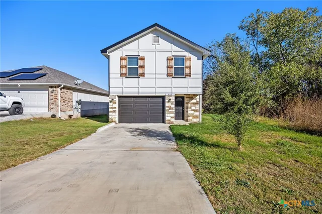 a front view of a house with a yard and garage