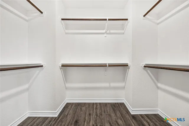 a view of walk in closet with empty racks