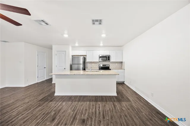 a view of kitchen with wooden floor and electronic appliances