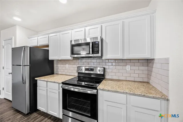 a kitchen with a refrigerator stove and microwave