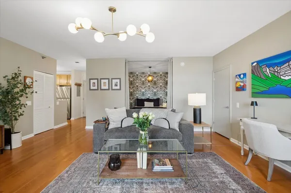 a living room with furniture a chandelier and a rug