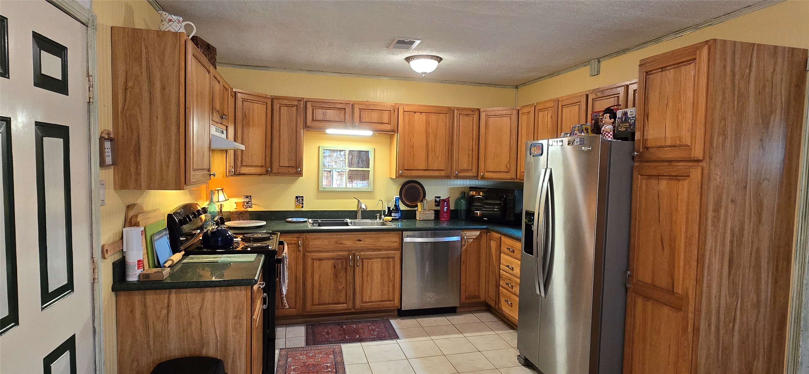 17018 Water Oak Drive Channelview, TX 77530 - Photo 2 of 40 a kitchen with a refrigerator a sink dishwasher and cabinets