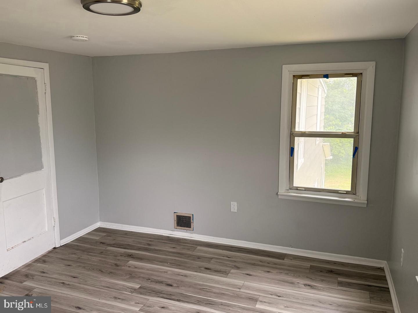 217 Smith Street Salem, NJ 08079 - Photo 13 of 23 an empty room with wooden floor and windows