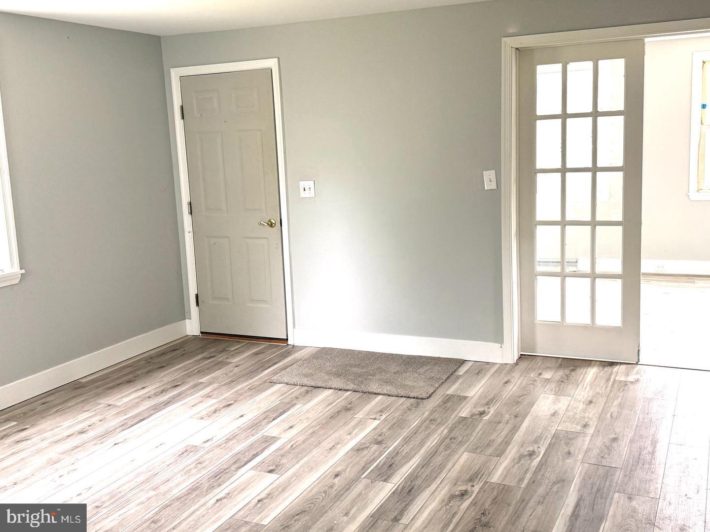217 Smith Street Salem, NJ 08079 - Photo 6 of 23 an empty room with wooden floor and windows