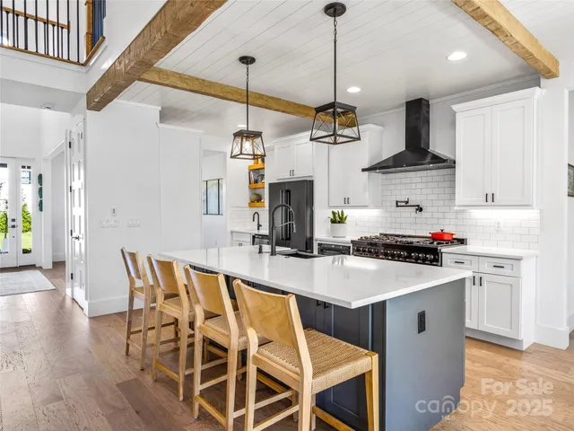 a kitchen with stainless steel appliances granite countertop a kitchen island a stove a table and chairs