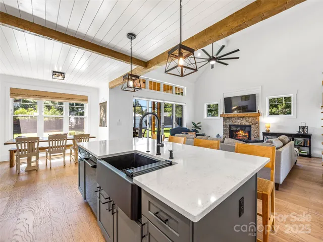 a kitchen with stainless steel appliances granite countertop a stove top oven a dining table and chairs with wooden floor