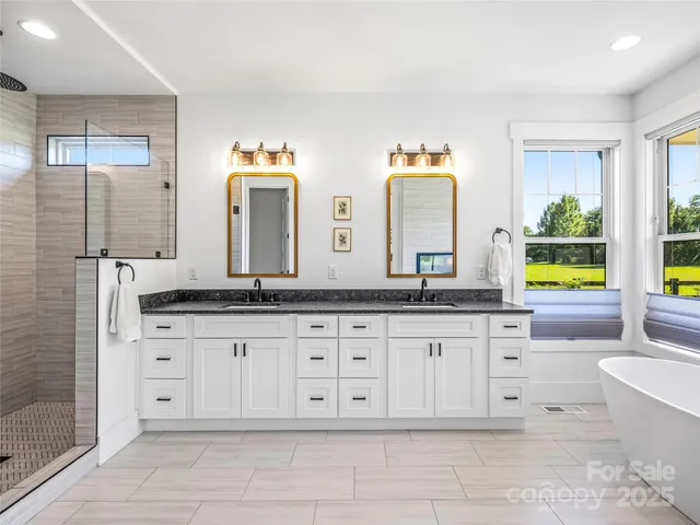 a bathroom with a granite countertop double vanity sink and a mirror