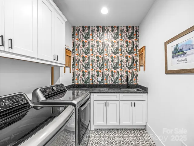 a kitchen with white cabinets a sink and a stove