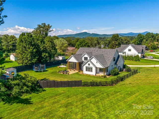 an aerial view of residential houses with outdoor space and trees