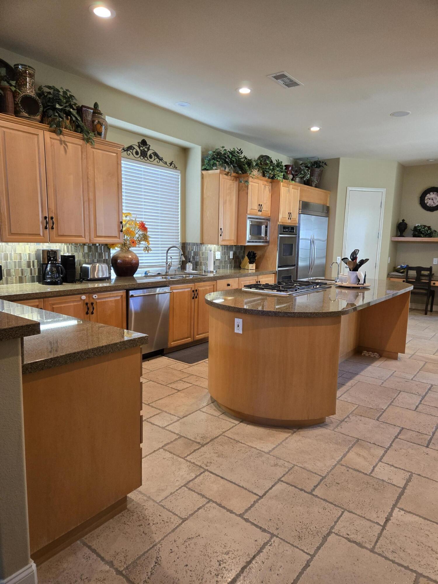 15 Vía Verde Rancho Mirage, CA 92270 - Photo 3 of 23 a kitchen with stainless steel appliances granite countertop a sink counter space cabinets and a large window