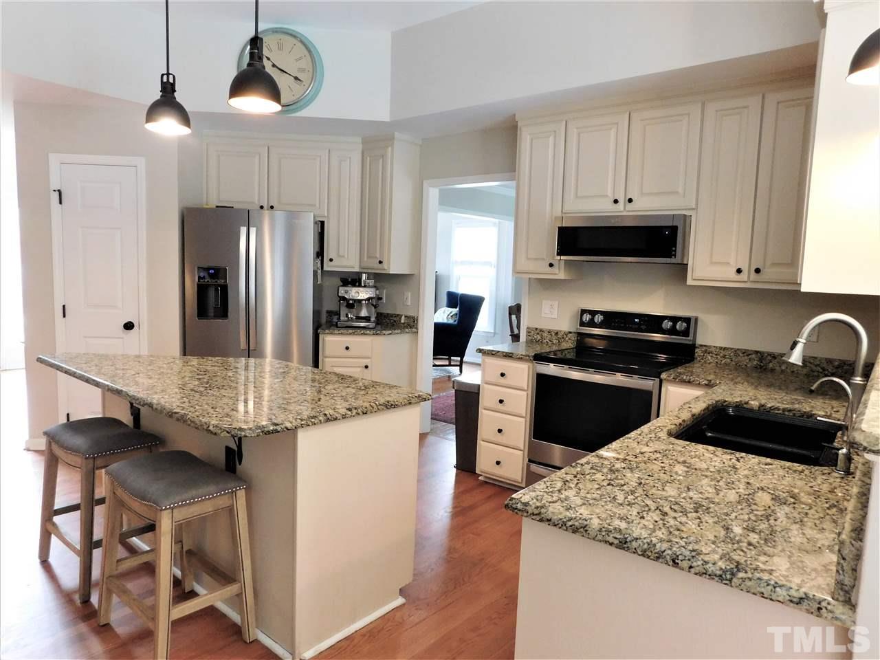 2332 Finley Ridge Lane Raleigh, NC 27615 - Photo 14 of 30 a kitchen with granite countertop kitchen island stainless steel appliances a stove sink microwave and cabinets