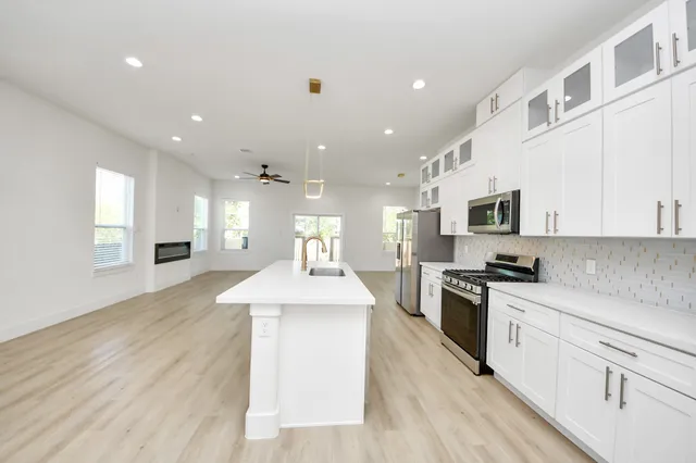 a kitchen with a sink wooden floor and stainless steel appliances