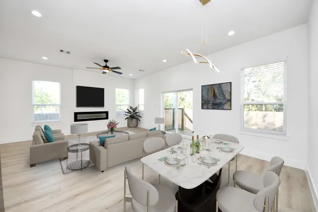 a view of an empty room with a window and kitchen view