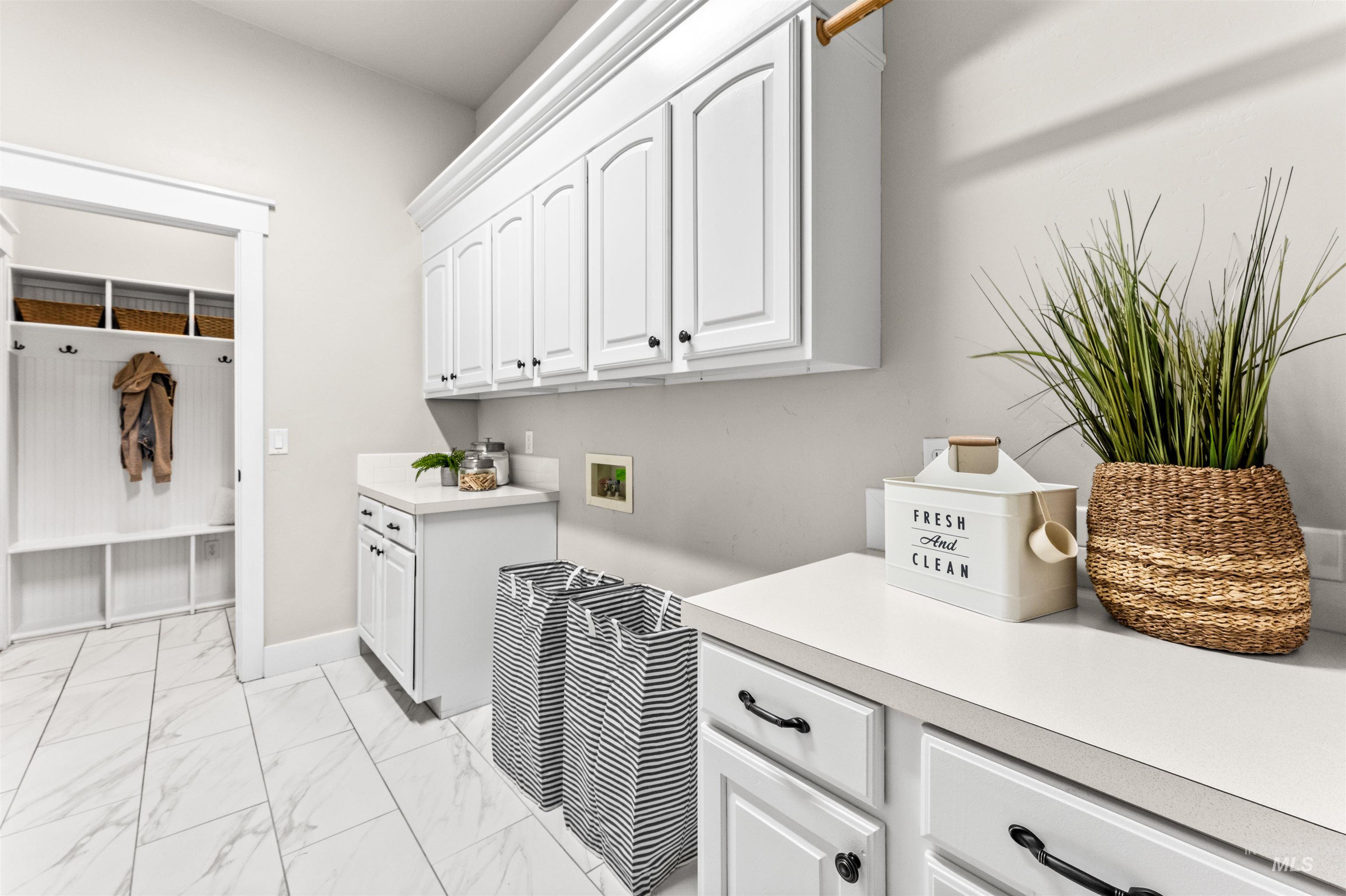 1177 East Riversong Drive Eagle, ID 83616 - Photo 28 of 36 Laundry area with cabinet space, light marble finish floors, and washer hookup