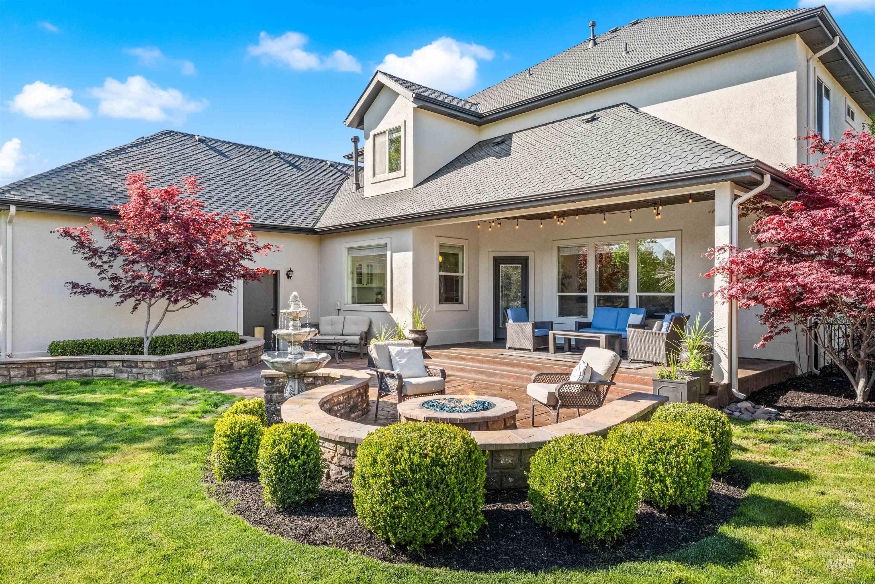 1177 East Riversong Drive Eagle, ID 83616 - Photo 30 of 36 Rear view of property with a patio area, stucco siding, an outdoor living space with a fire pit, and a lawn