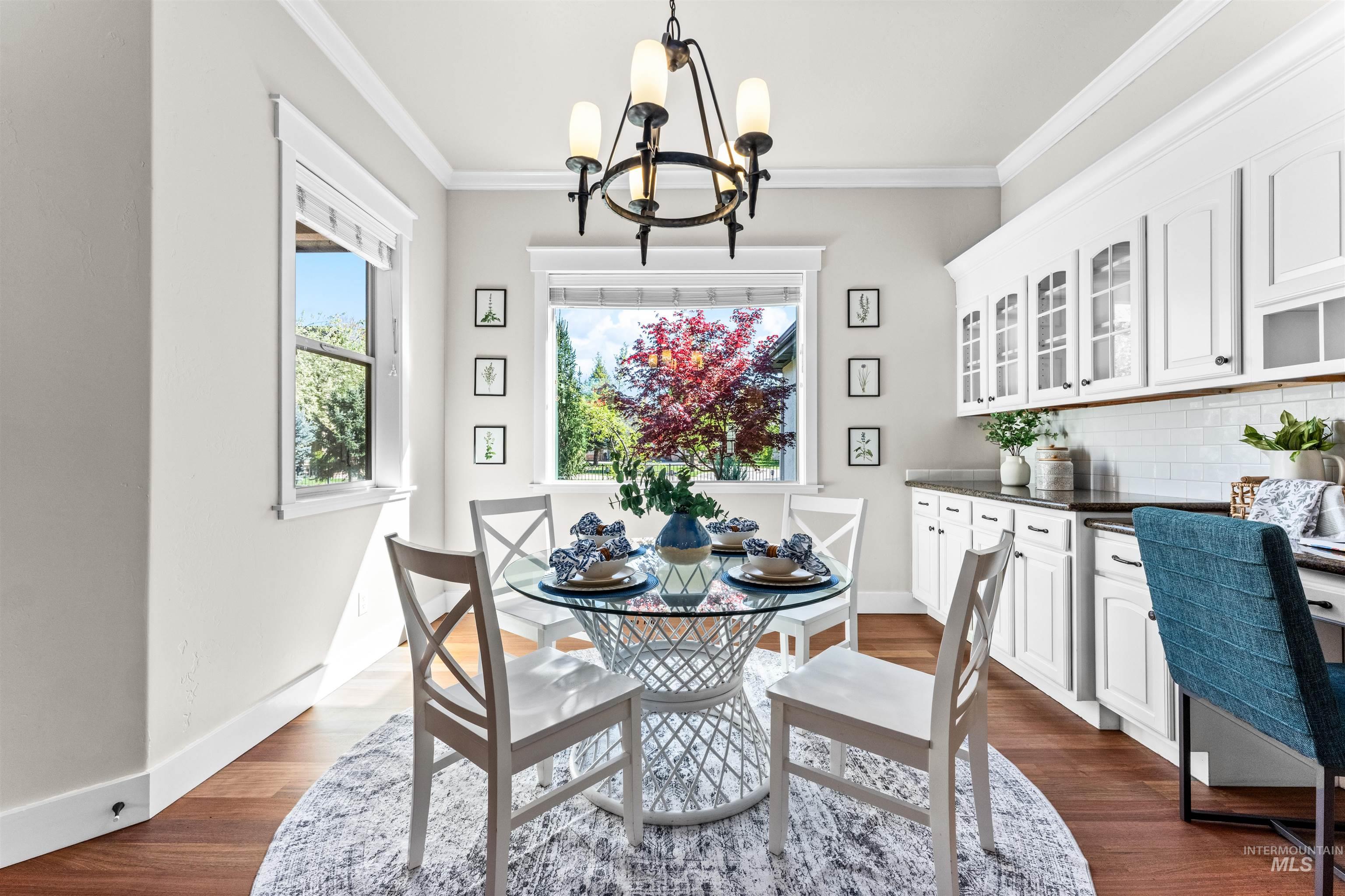1177 East Riversong Drive Eagle, ID 83616 - Photo 8 of 36 Dining room with crown molding, dark wood-style flooring, and a chandelier