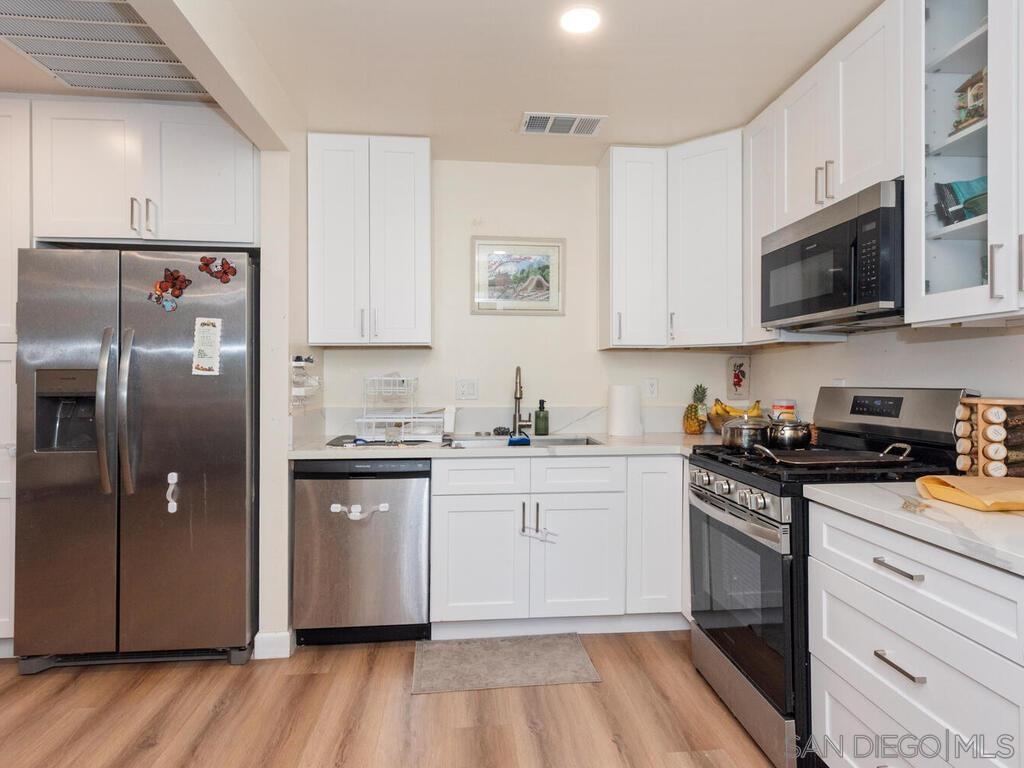 1027 Chestnut Street Escondido, CA 92025 - Photo 17 of 35 a kitchen with stainless steel appliances granite countertop a stove a sink and a refrigerator