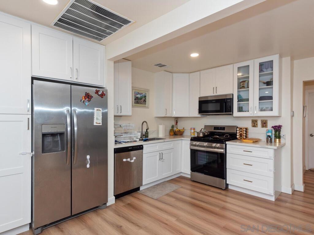 1027 Chestnut Street Escondido, CA 92025 - Photo 23 of 35 a kitchen with stainless steel appliances granite countertop a stove a sink dishwasher a refrigerator and a microwave oven with wooden floor