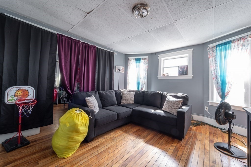 217 Beacon Street Worcester, MA 01610 - Photo 21 of 39 a living room with furniture a window and wooden floor