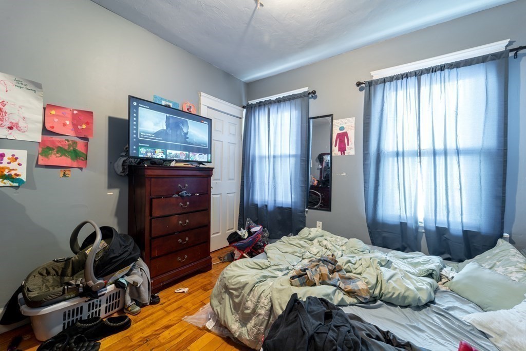 217 Beacon Street Worcester, MA 01610 - Photo 27 of 39 a bedroom with a bed and wooden floor
