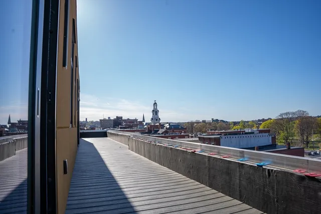 a view of a balcony with wooden floor and iron stairs
